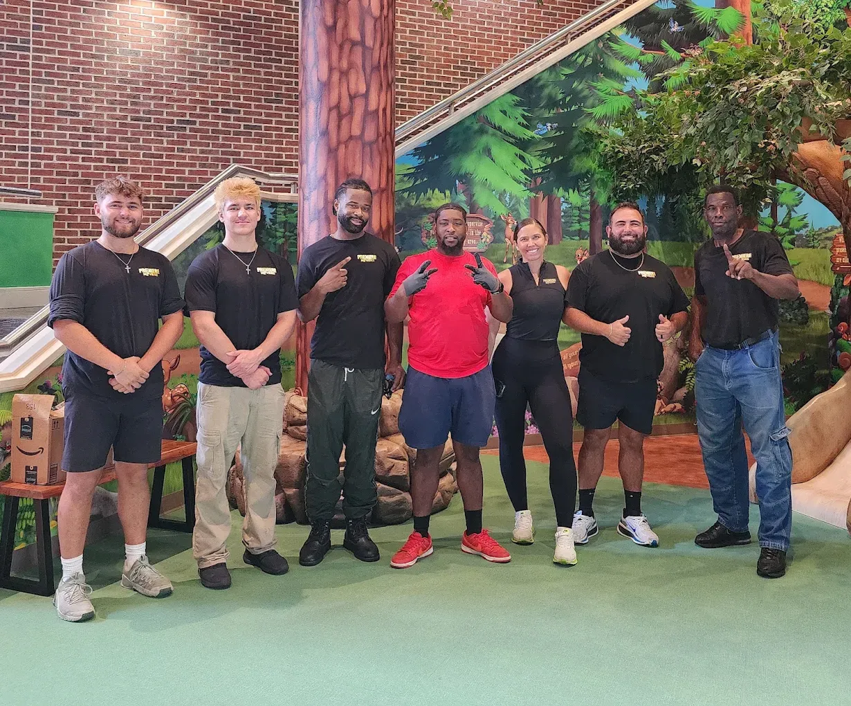 A seven person Premiere Movers crew in branded shirts inside a commercial building during a move